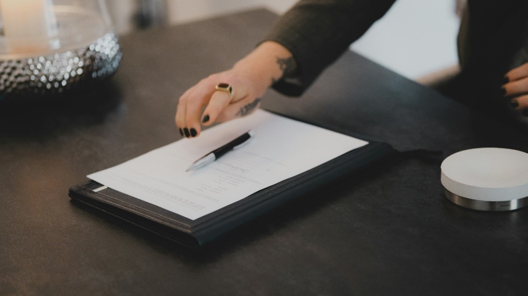 Trust deed documents on a desk being reviewed by a lady.