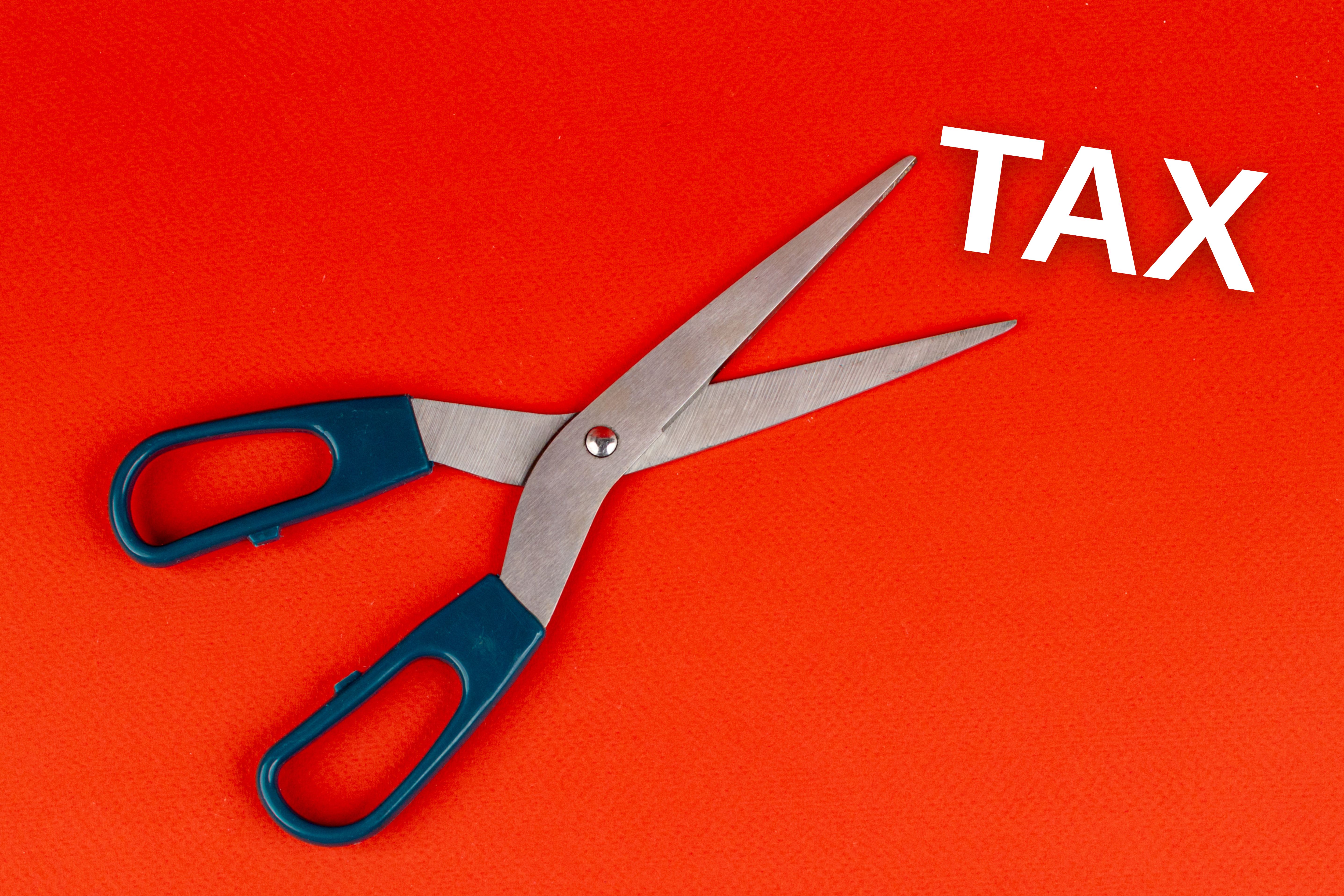 Image of scissors cutting into the word tax